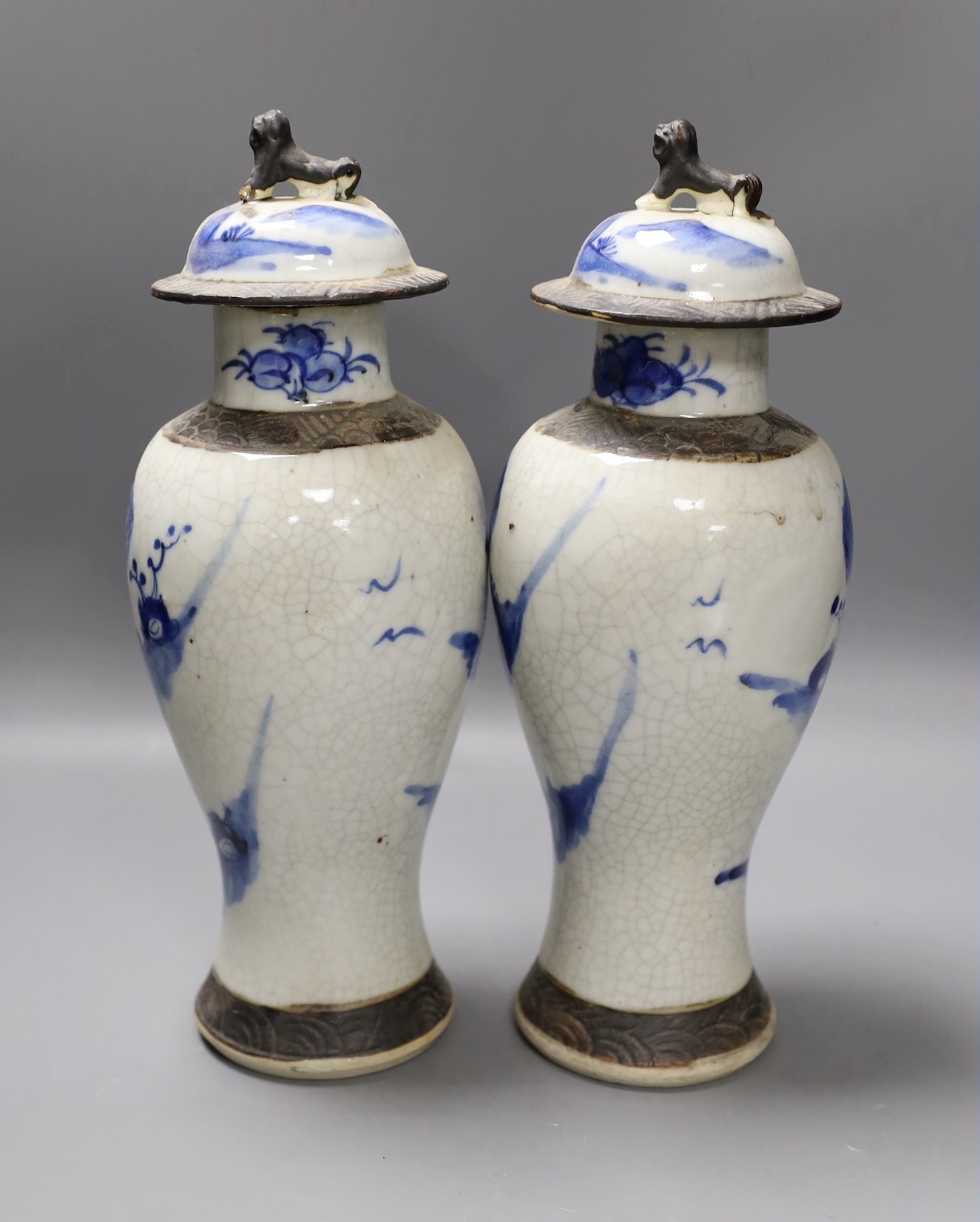 A pair of early 20th century Chinese blue and white crackle glaze vases and covers, 30cm